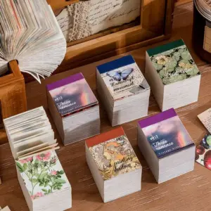 01-15 Vintage-Papierblöcke mit farbigen Deckblättern, Blumen- und Schmetterlingsmotiven, daneben eine Hand beim Fächern der Blätter