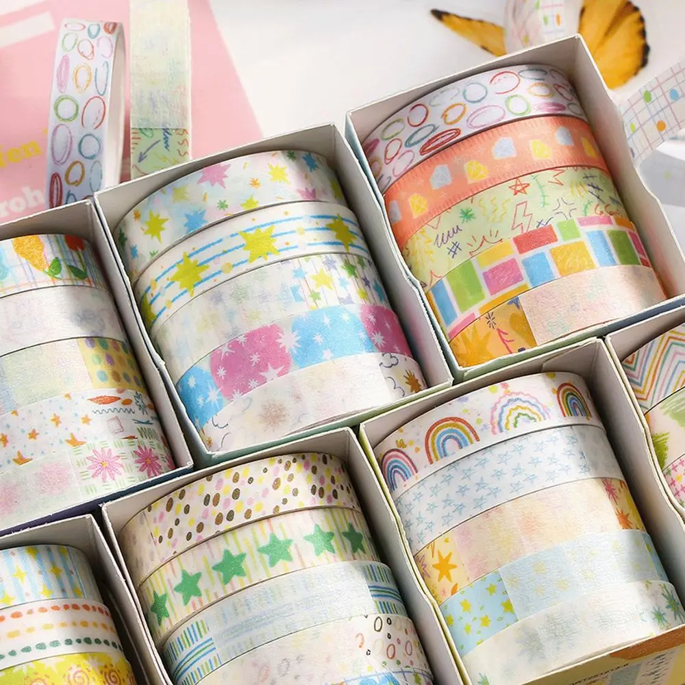 Pastellfarbene Washi-Tape-Rollen in weißen Schachteln mit abgerollten Streifen